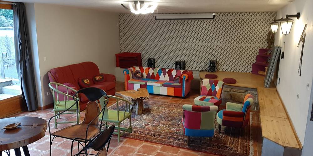 coin canapés dans salle de séjour, avec vidéoprojecteur au fond -  Le Jardin Mirandou (Auvergne-Rhône-Alpes, Haute-Loire)